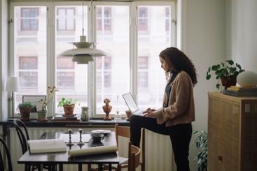 Side view of female construction engineer using laptop...