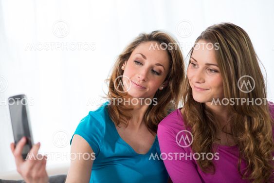 portrait of two beautiful girls making a selfie