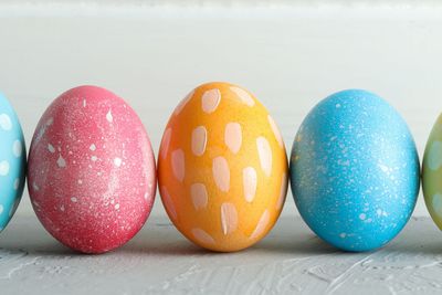 Decorated Easter eggs on color background, closeup. Space...