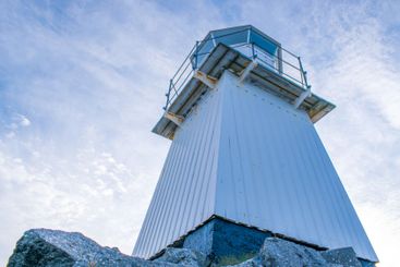 Old lighthouse on a rocky seashore, view from below