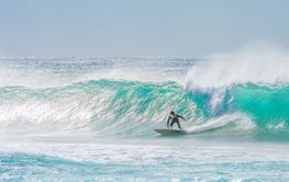 young adult surfing on a big wave in the ocean