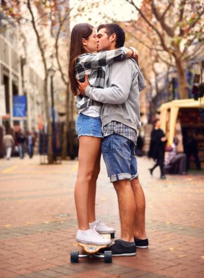 Couple, skateboarding and kissing in city, in love and...