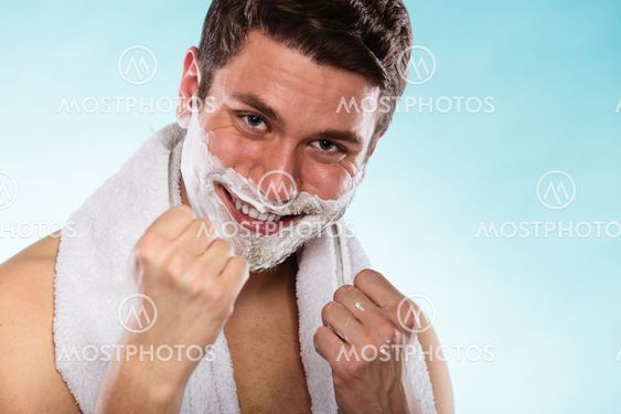 Happy young handsome man with shaving cream foam.