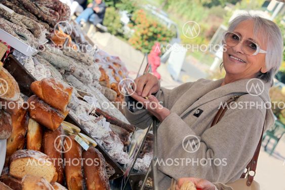 Woman buying bread from market stall
