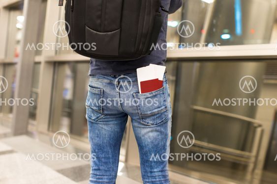 Closeup passports and boarding pass in the pocket of jeans at airport