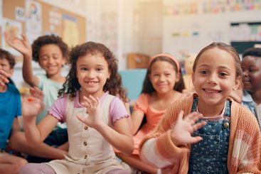Waving, happy and portrait of children in classroom for...