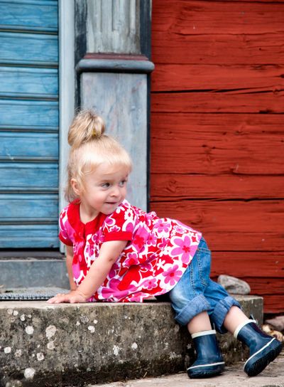 Cute little girl on the stairs to an old swedish cottage