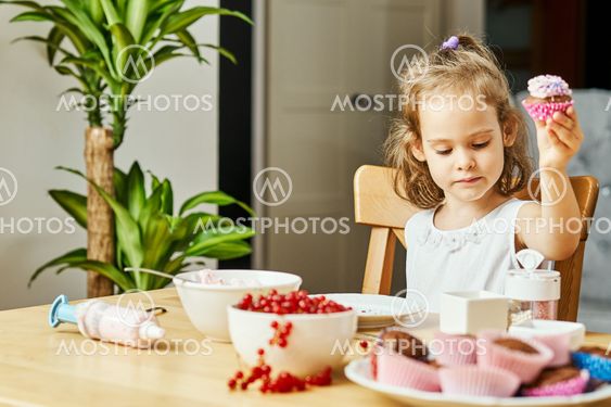 girl in a white dress decorates and eats a delicious...