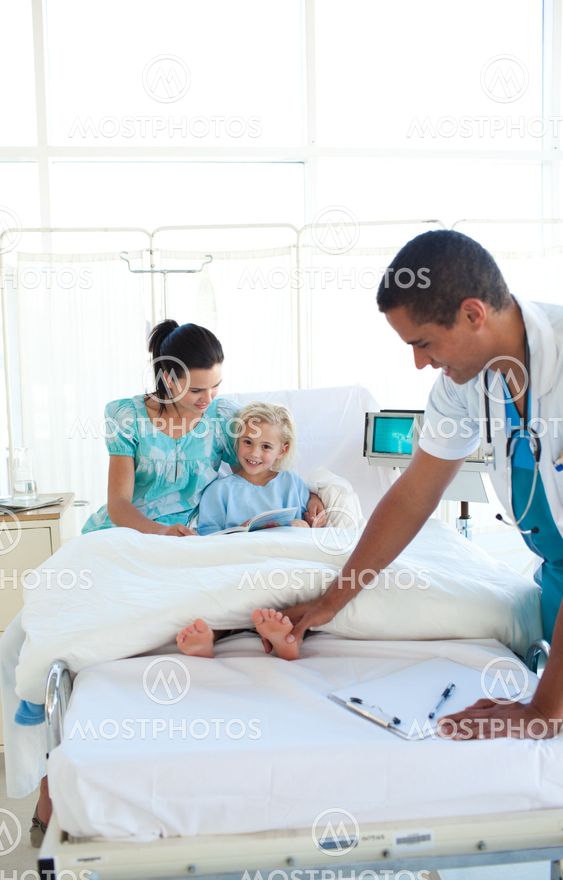 Smiling doctor examining little girl's feet