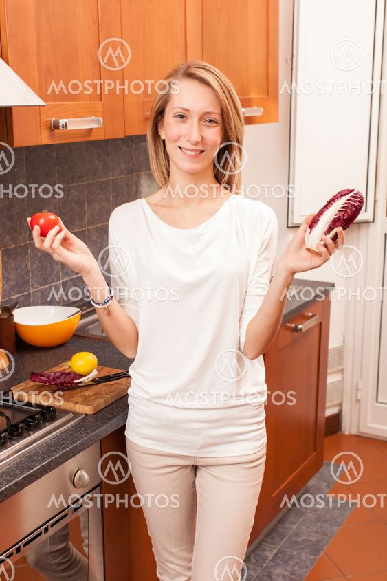 Young Woman Holding Vegetables in the Kitchen