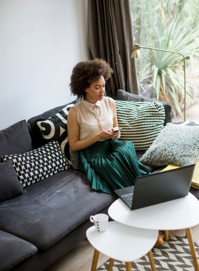 Attractive young woman working on laptop and using...