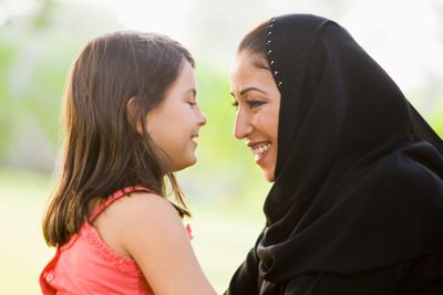 A Middle Eastern woman and her daughter sitting in a park