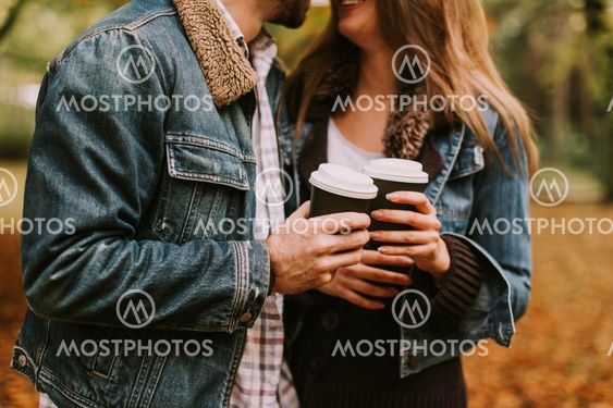 Romantic couple with coffee walking outdoors in the...