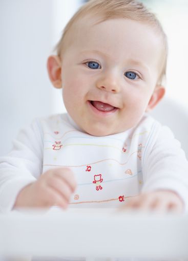 Baby boy, happy and high chair in home, relax and...