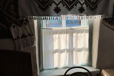 Vintage window with embroidered curtains in soft sunlight