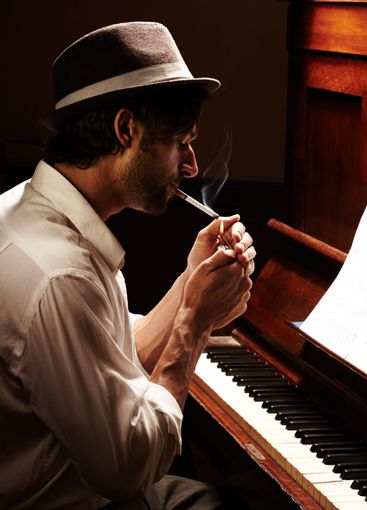 Moody musician. Profile of a handsome man having a smoke...