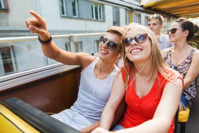 happy teenage couple traveling by tour bus