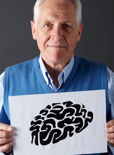 Senior man holding ink drawing of brain