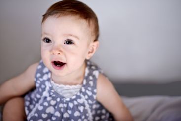 Happy baby, girl and bed with playful childhood for...