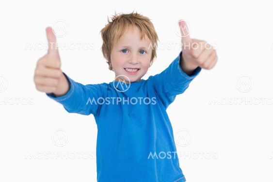 Portrait of young boy gesturing double thumbs up