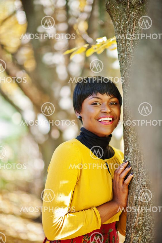 African american girl at yellow and red dress at golden...