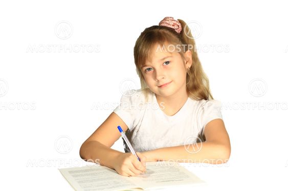 Beautiful little girl wrote in a notebook. She does homework.