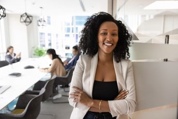 Happy beautiful female African business leader posing in...