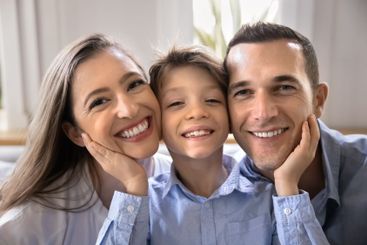 Happy kid and couple of parents posing for family portrait