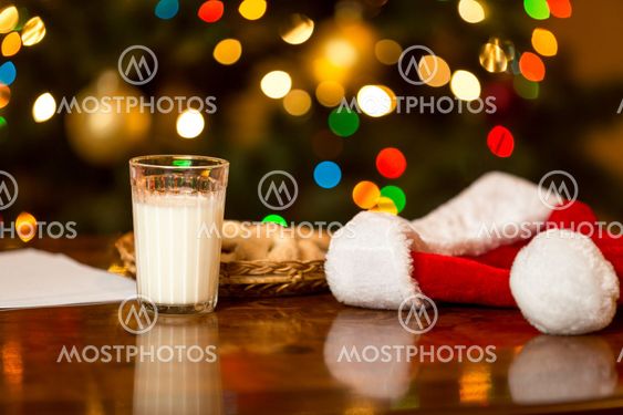 Closeup of glass of milk and cookies for Santa on table