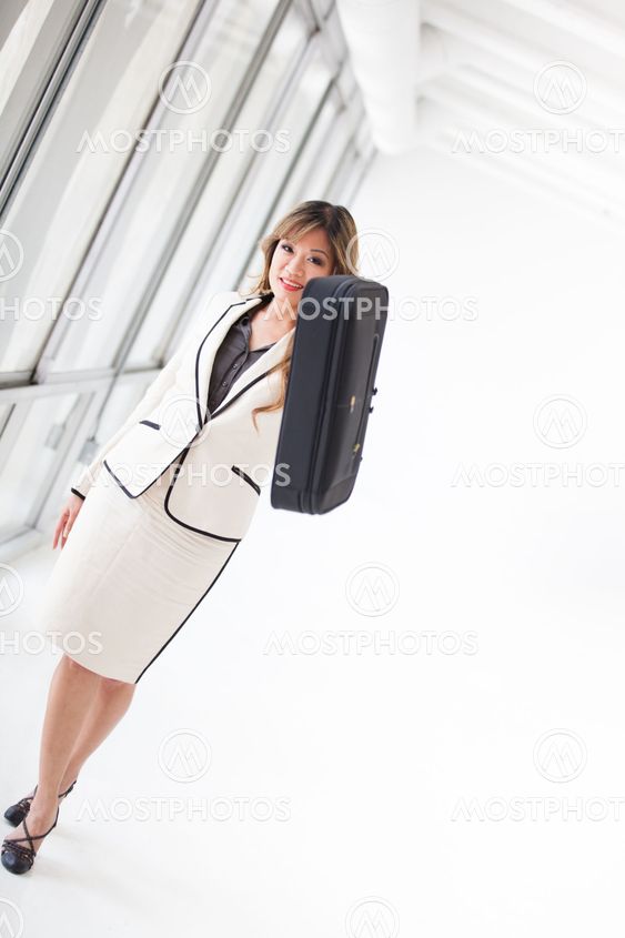 Asian Business Woman walking while on her cell phone