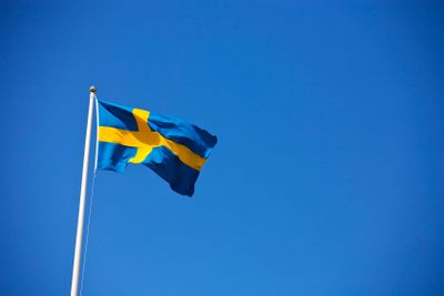 Den svenska flaggan mot en blå himmel. 
