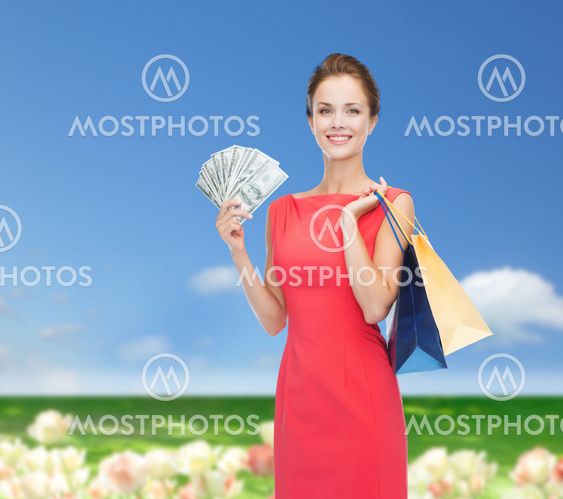 smiling woman in red dress with shopping bags