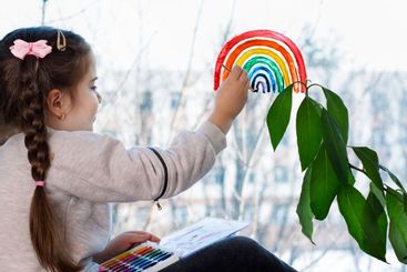 Girl painting rainbow during Covid-19 quarantine at...