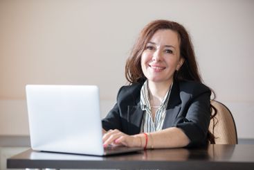 Business brunette woman at desk with laptop online in...