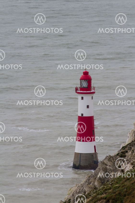 Lighthouse red and white striped on stormy winter day.
