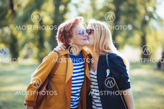 Mature mother and adult daughter enjoying a day in the park