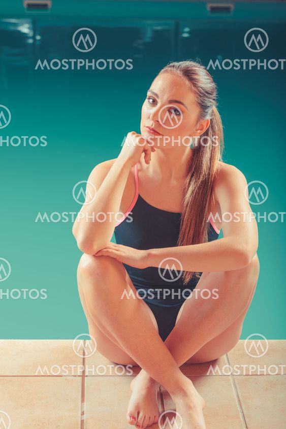 Sporty fit woman at swimming pool edge poolside.