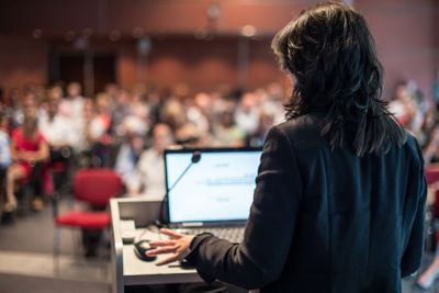 Public speaker giving talk at Business Event.