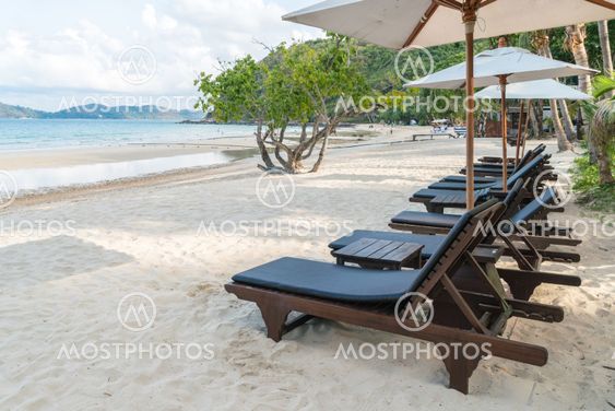 Beautiful beach chairs with umbrella on tropical white...
