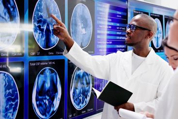Doctors In Clinic Looking At Brain MRI Scan