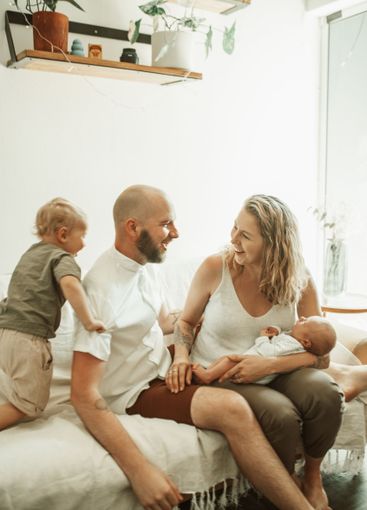 Parents, children and a family having fun on the sofa in...