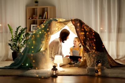 family with tablet pc in kids tent at home