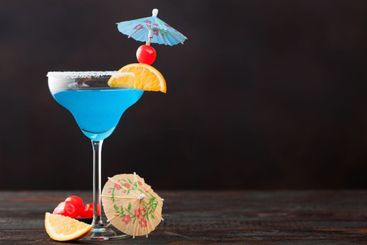 Blue lagoon summer cocktail in margarita glass with...