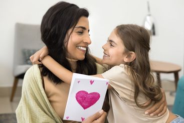 Little daughter congratulate mother on holiday, close up