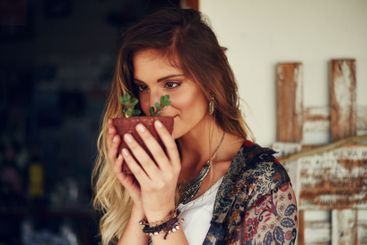 Woman, pot plant and smell in garden with growth, leaves...