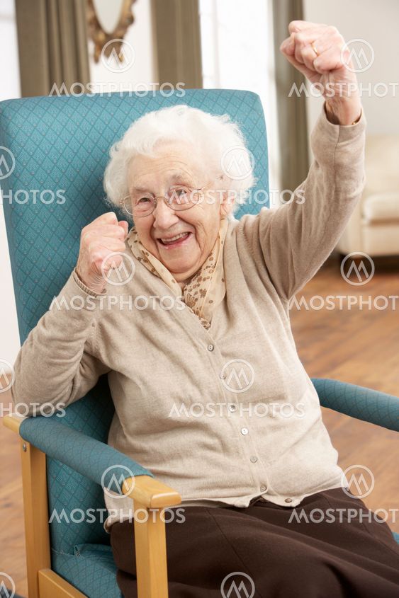 Senior Woman Celebrating In Chair At Home