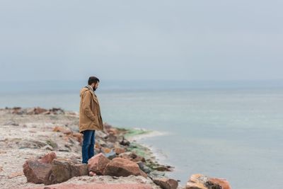 man standing on seashore