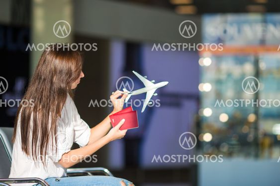 Pretty young female passenger with small model airplane...