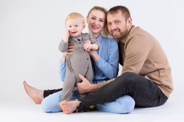 Over gray background happy mom dad with one year old...