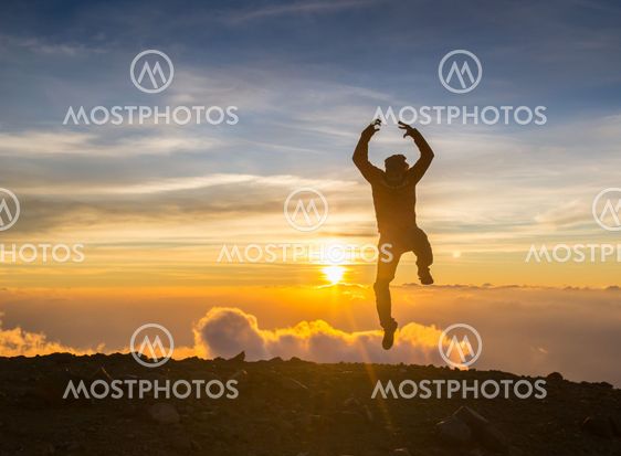 Man jump through the gap on sunset fiery background....